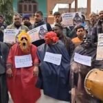 वाराणसी साकेत नगर कॉलोनी में भू-माफियाओं के खिलाफ विरोध प्रदर्शन, चौराहे पर बैठे राक्षस और ढोल नगाड़े की आवाज।